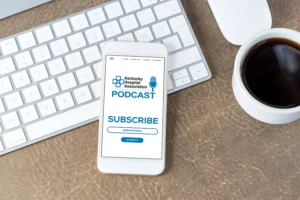 Photo of smartphone with KHA Podcast logo, and Subscribe button