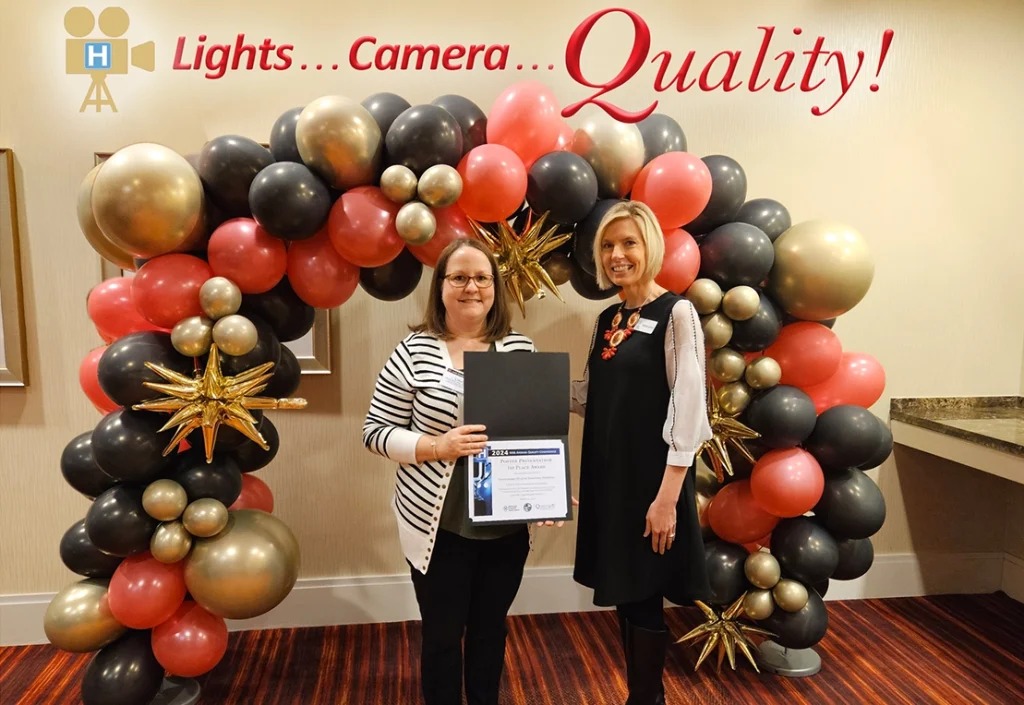 Melanie Landrum presents the KHA 2024 Quality Poster Presentation Award to 1st Place winner