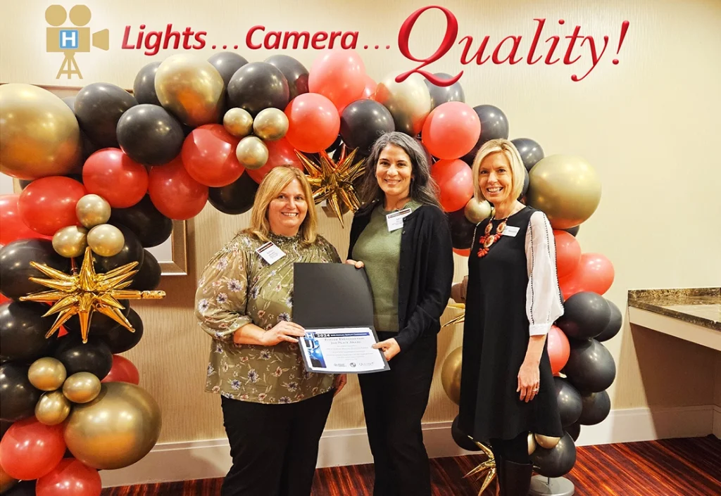 Melanie Landrum presents the KHA 2024 Quality Poster Presentation Award to 2nd Place winner